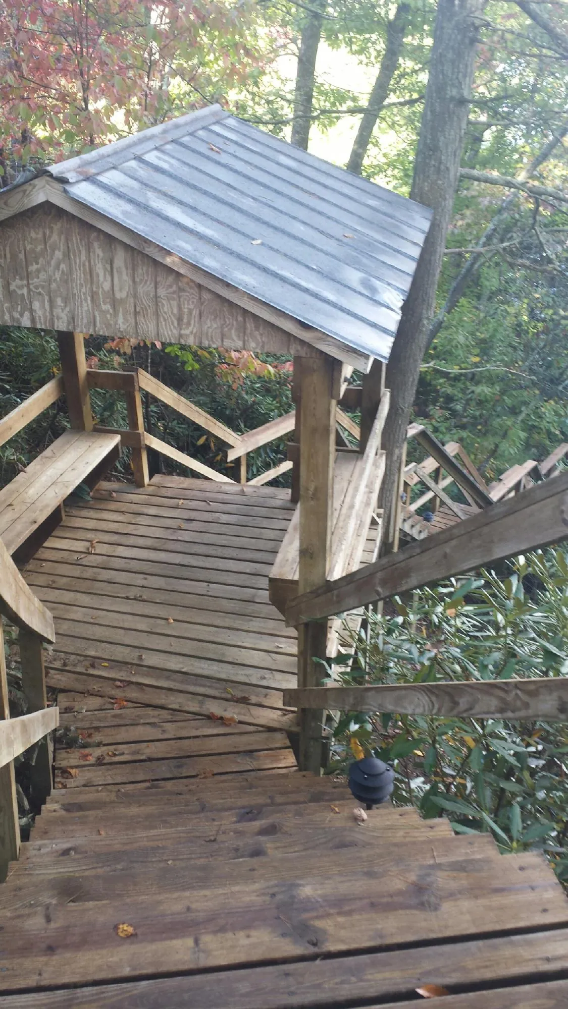 Metal roofed shelter over wooden steps on a wooded walkway — Skylight Repair & Installation work by our crew in Westmoreland